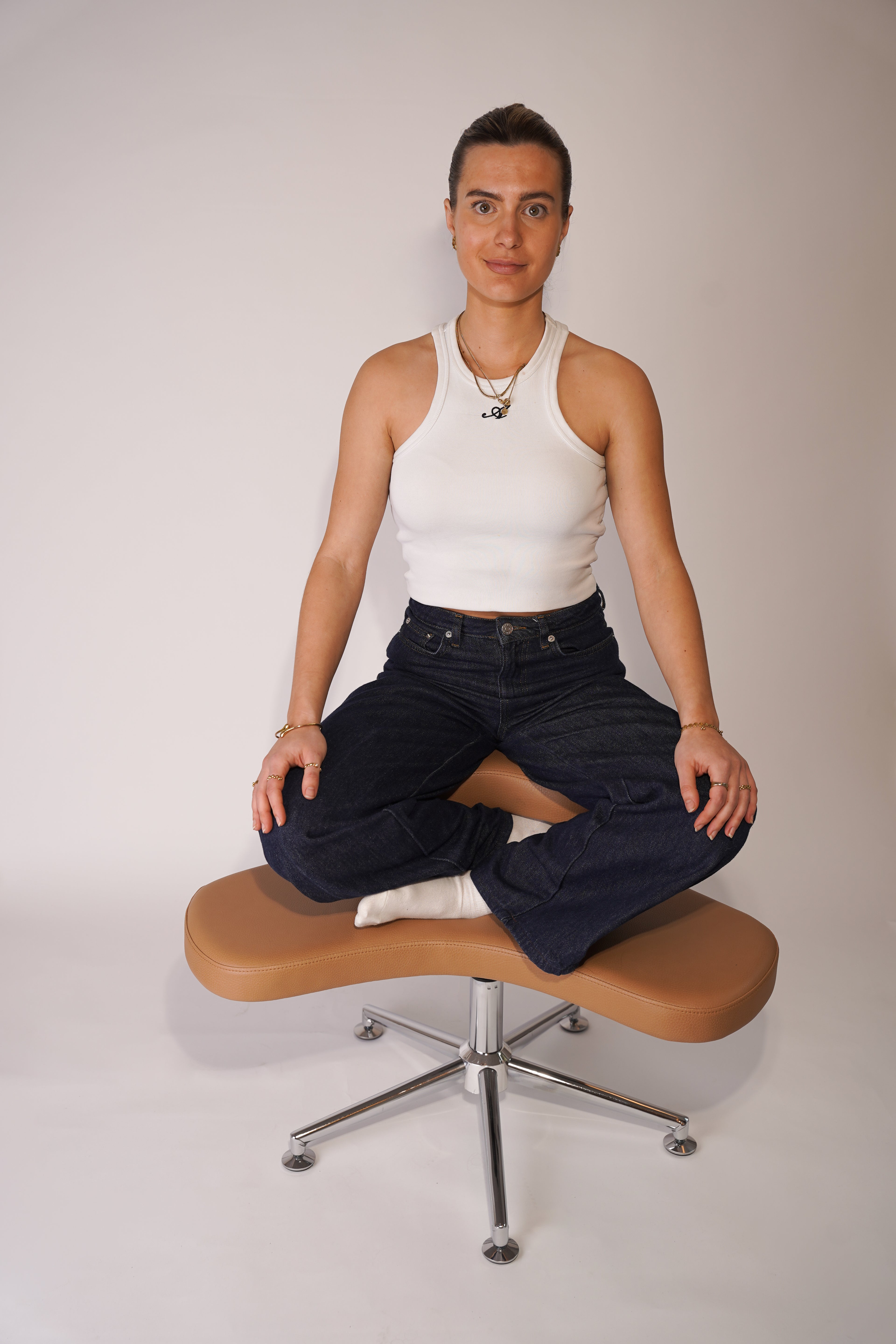 Model sitzt im Schneidersitz auf dem Yogi Seat, die Hände locker auf den Knien abgelegt, den Blick in die Kamera