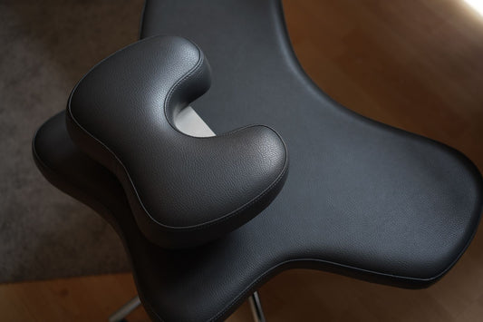 Produktfoto vom Schneidersitzstuhl (Yogi Seat) mit einer Aussparung im oberen SItzkissen für das Steißbein gegen Steißbeinschmerzen.